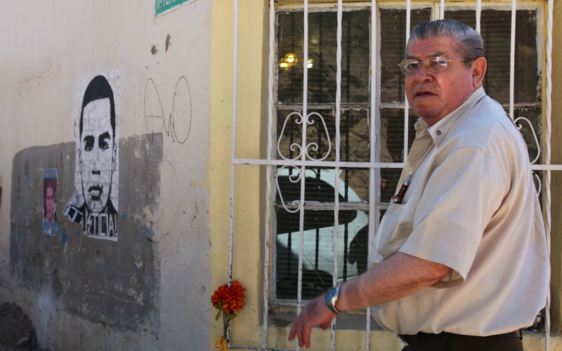 Sanchez shows posters on the side of his home above the exact spot where Rodriguez died.