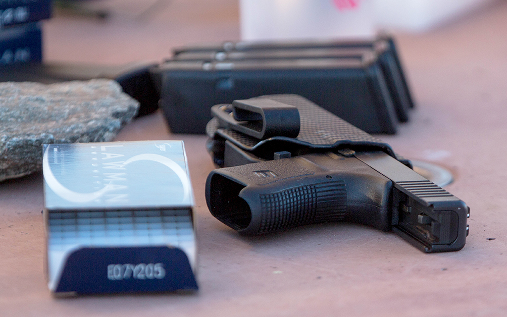 Gun, bullets and magazine on a table.