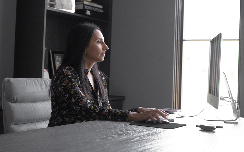 Anita Verma-Lallian works at her desk on April 13, 2023, in Paradise Valley. Verma-Lallian is the owner of Camelback Productions, which she says is Arizona’s first woman- and South Asian-owned film production and entertainment company. (Photo by Gianna Abdallah/Cronkite News)
