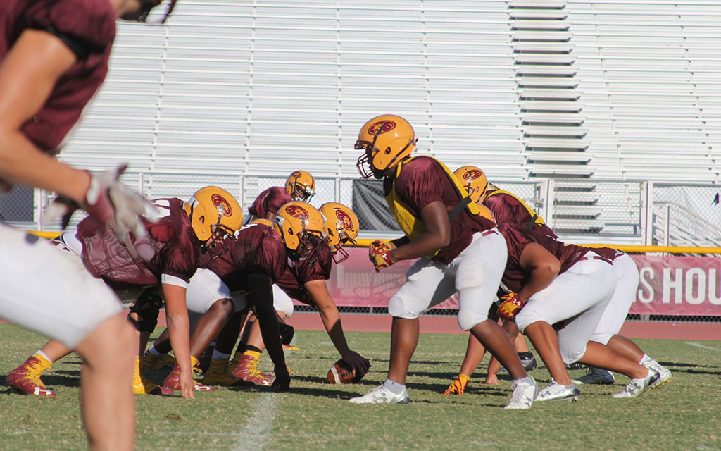 Football players at the line before snap.