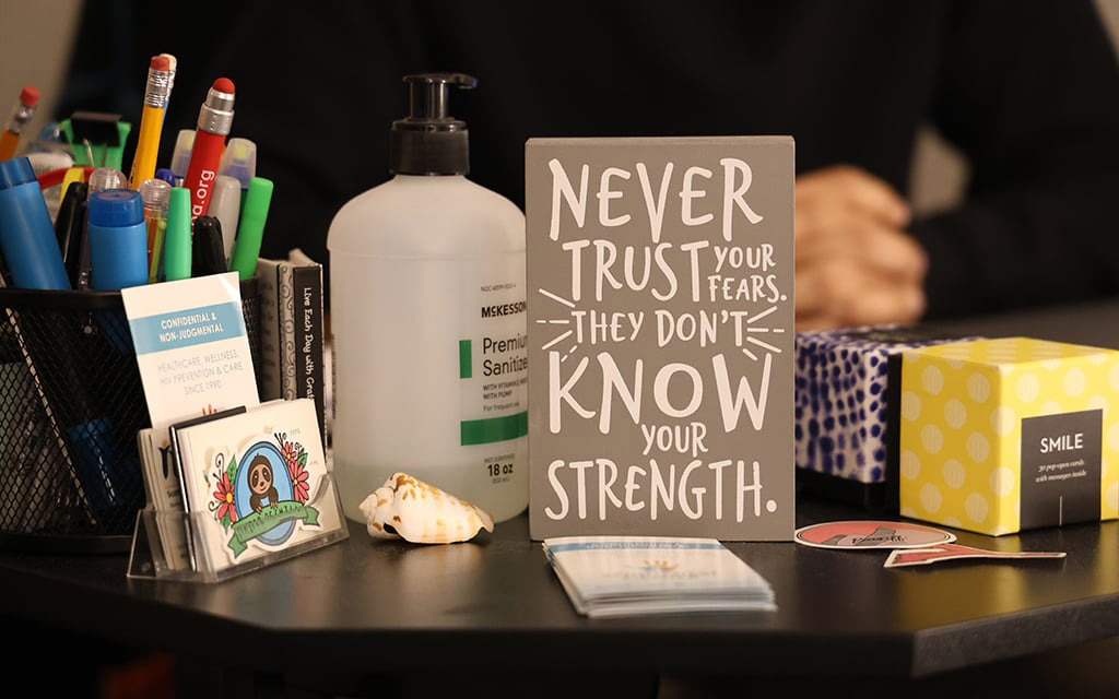 Un lema alentador sobre la mesa de Christopher Carrillo, gestor de casos en el Southwest Center for HIV/AIDS de Phoenix. Habló sobre las pruebas y el tratamiento del VIH y las afirmaciones que le han ayudado. (Foto de Jack Orleans/Cronkite Noticias)