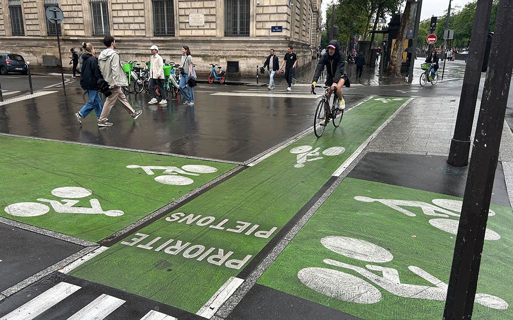 A newly painted logo showcases the Paris Olympics on a bike lane near the Stade de France in Paris. The logo is one of the improvement projects the City of Paris carried out to beautify the streets near Olympic venues. (Photo by Zach Bradshaw/Special for Cronkite News)