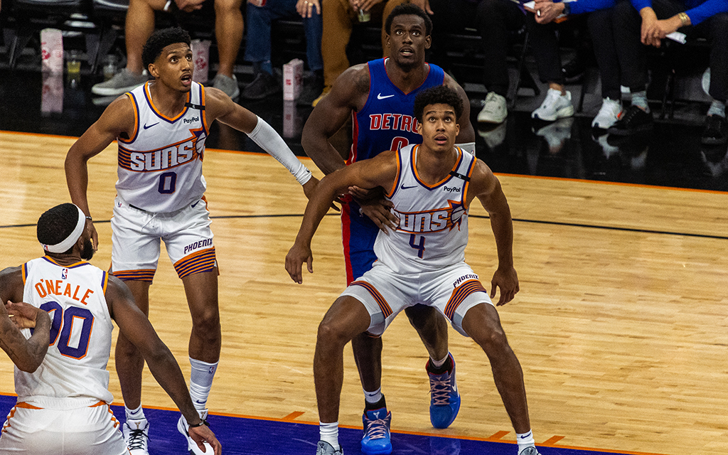 Basketball players, Ryan Dunn, Oso Ighodaro, and Royce O'Neale from the Phoenix Suns and Jalen Duren from the Detroit Pistons during a game.
