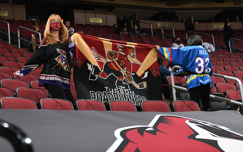 Two fans hold up a flag at the Tucson Roadrunners game