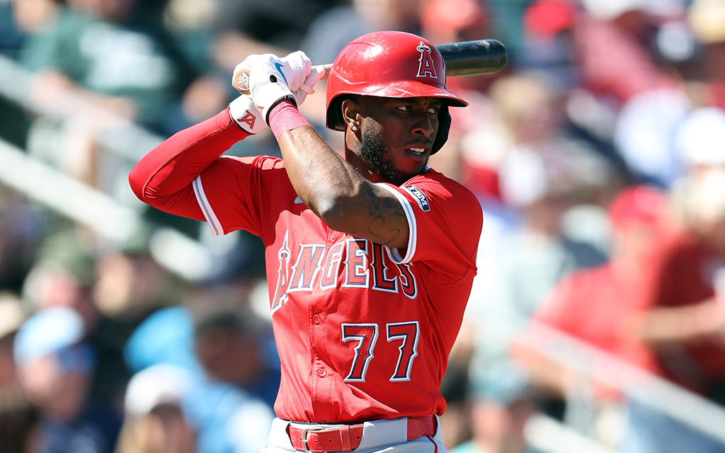 Baseball player in a red uniform in batting stance.
