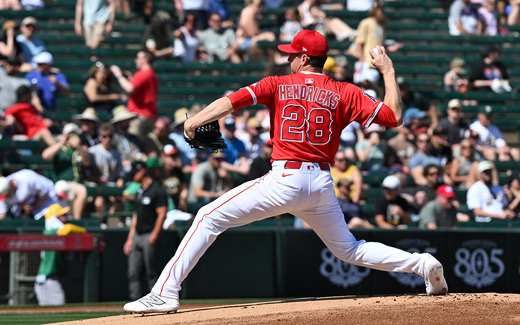 A baseball player in a red jersey mid-pitch on the field.