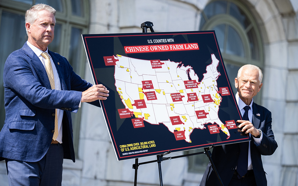Sen. Roger Marshall and Peter Navarro display a map labeled "U.S. Counties with Chinese Owned Farm Land" with highlighted military base areas.